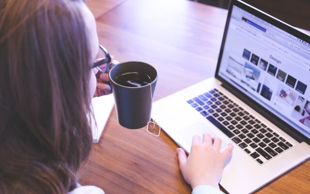 Frau am Schreibtisch mit Laptop und Kaffee
